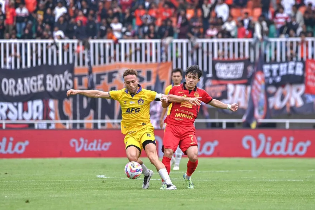 Review Pekan 12 Liga 1: Persebaya Kokoh, Striker Arema FC Makin Tajam Foto : playmaker Persik, Ze Valente duel bola dengan Ryo Matsumura (c)media-persik