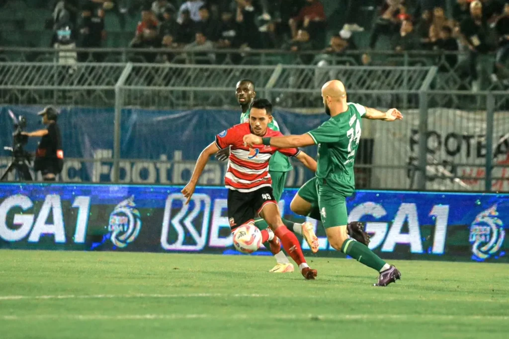 Review Pekan 12 Liga 1: Persebaya Kokoh, Striker Arema FC Makin Tajam Foto : Taufik Hidayat berusaha melewati hadangan pemain Persebaya (c)media-maduraunited
