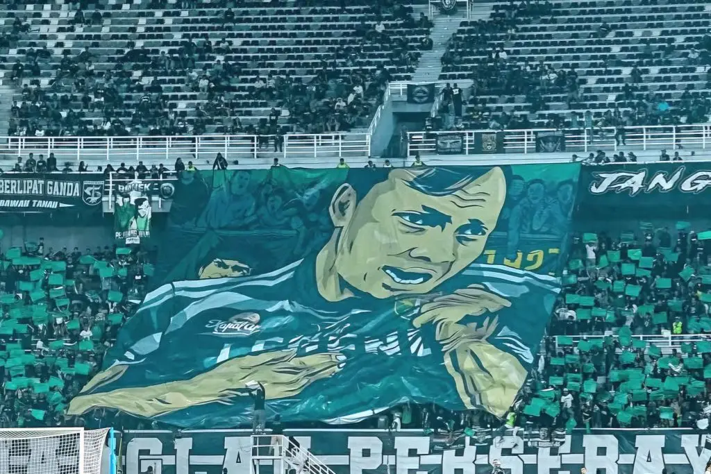 Mengenang Bejo Soegijantoro, Legenda Yang Berpulang Foto : suporter Persebaya membentangkan banner raksasa bergambar wajah sang legenda (c)X-persebayaupdate